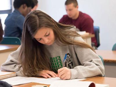 Female student working at her classroom desk.